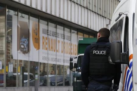 A Police officer stands in front of a car dearlership during a police operation after fugitive Mohamed Abrini was arrested in Anderlecht, near Brussels, Belgium, April 8, 2016. REUTERS/Yves Herman