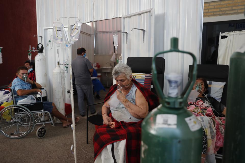 Patients breathe from oxygen tanks as they wait for a bed to open in the COVID-19 treatment area of the hospital in Villa Elisa, Paraguay, Tuesday, April 20, 2021. (AP Photo/Jorge Saenz)