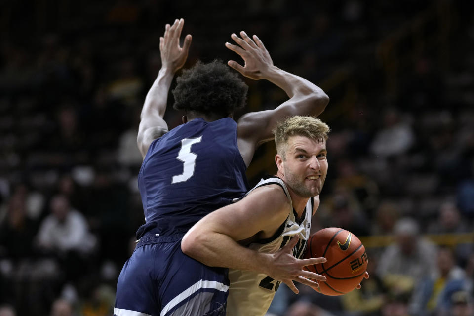 Iowa forward Ben Krikke (23) drives to the basket around North Florida guard Dorian James (5) during the second half of an NCAA college basketball game, Wednesday, Nov. 29, 2023, in Iowa City, Iowa. (AP Photo/Charlie Neibergall)