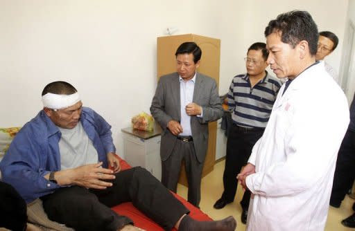 Chinese Ambassador to Zambia Zhou Yuxiao (C) visits a victim of the Collum Coal mine wages riot at Levy Mwanawasa Hospital on August 6, 2012 in Lusaka. The killing of a Chinese mine boss last weekend has left Zambian President Michael Sata's government rushing to reassure foreign investors on their safety