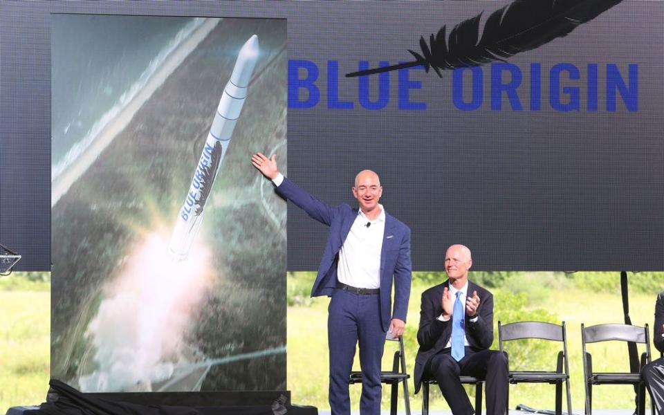 Jeff Bezos debuts a Blue Origin launch vehicle on Sept. 15, 2015, as Florida Gov. Rick Scott applauds during a press conference at Cape Canaveral Air Force Station.