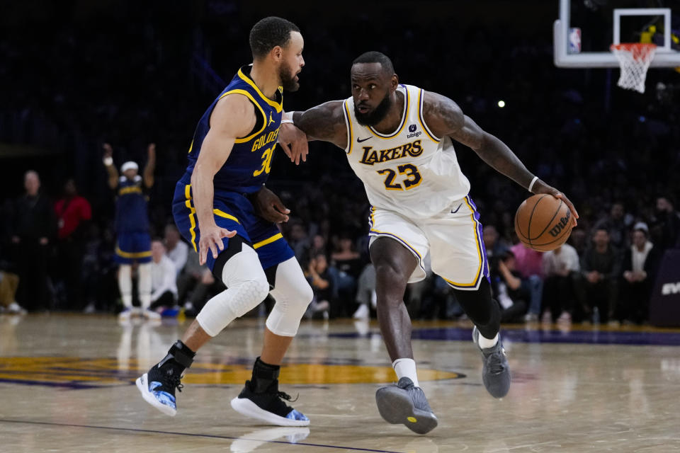 Golden State Warriors guard Stephen Curry (30) defends against Los Angeles Lakers forward LeBron James (23) during the second half of an NBA basketball game in Los Angeles, Saturday, March 16, 2024. (AP Photo/Ashley Landis)