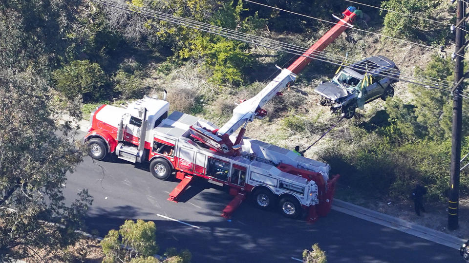 Workers, pictured here moving Tiger Woods' car after the horror car crash.