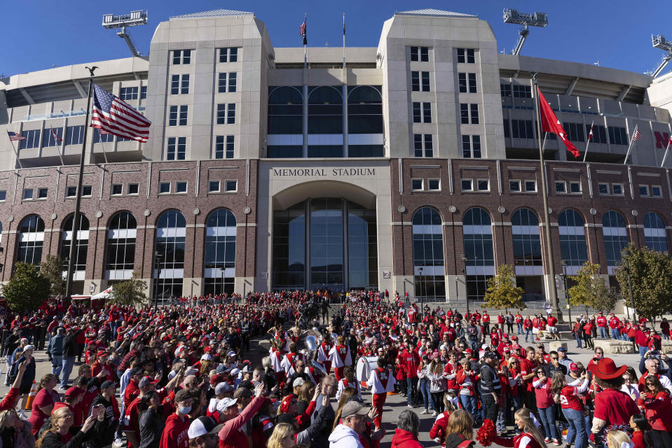 FILE - Nebraska fans cheer as the marching band leads the team's arrival at Memorial Stadium before an NCAA college football game against Purdue, Saturday, Oct. 30, 2021, in Lincoln, Neb. Almost 83,000 tickets have been sold for Nebraska's outdoor college volleyball doubleheader at Memorial Stadium in Lincoln on Aug. 30, 2023. The event starts with a Division II exhibition between Wayne State and Nebraska-Kearney and will be followed by a regular-season match between the Cornhuskers and Omaha. (AP Photo/Rebecca S. Gratz, File)