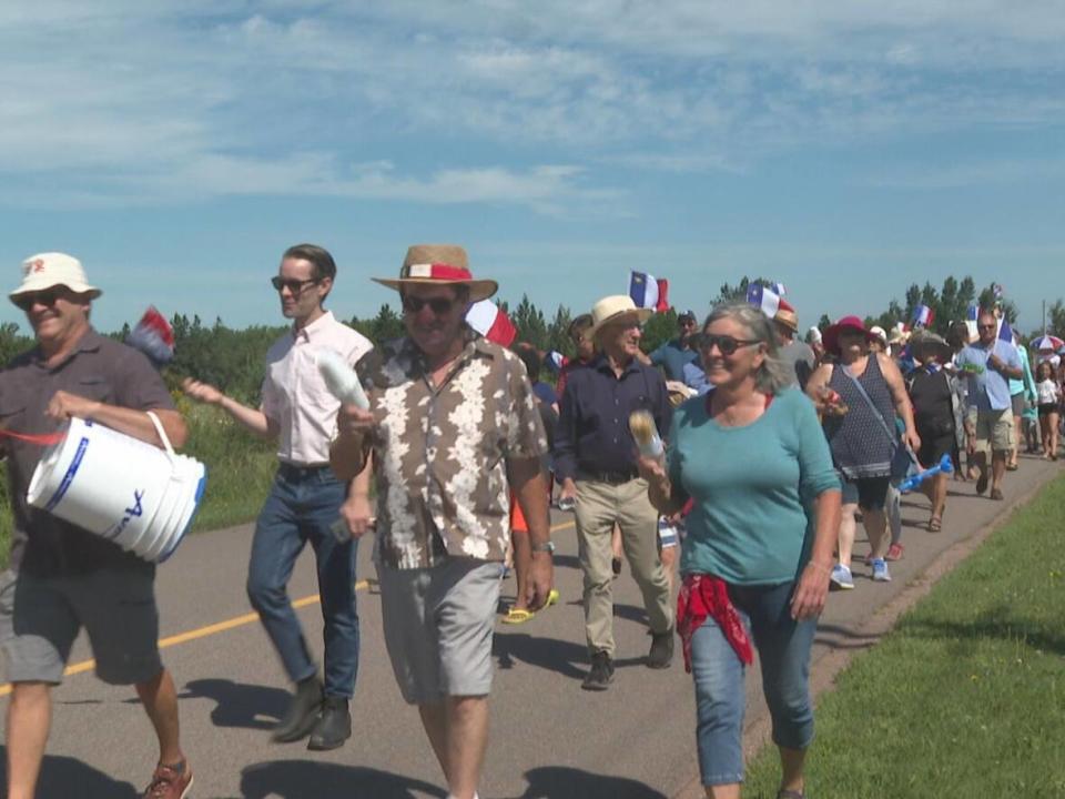 Members of the P.E.I.'s Acadian community grabbed their noisemakers and took part in a tintamarre commemorating National Acadian Day at noon on Monday in Rustico, P.E.I. (Kate McKenna/CBC - image credit)