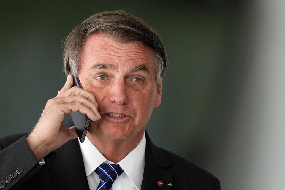 Brazilian President Jair Bolsonaro talks on cell phone after meeting with Colombia's President Ivan Duque at Planalto presidential palace in Brasilia, Brazil, Tuesday, Oct. 19, 2021. Duque is on a two-day visit to Brazil. (AP Photo/Eraldo Peres)