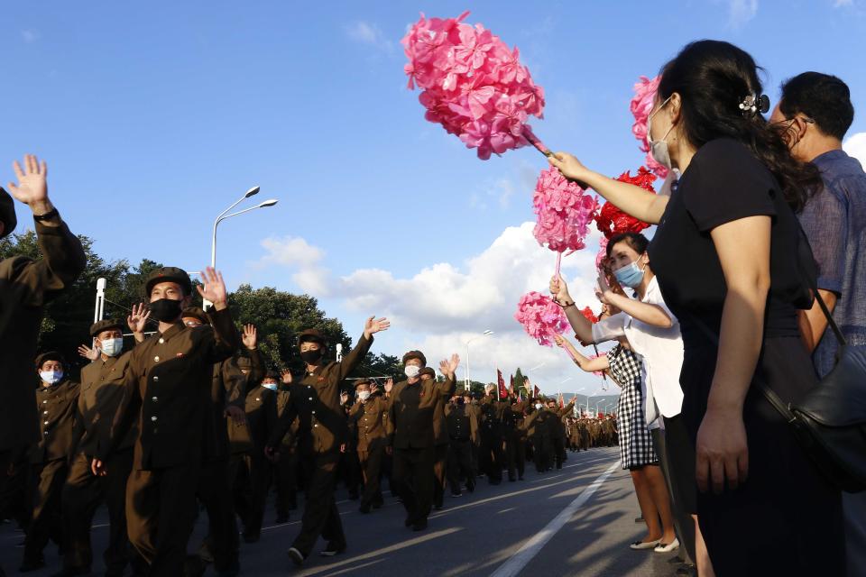 Locals cheer a gathering of thousands of political party members in support of the recovery efforts from typhoon damage at the plaza of the Kumsusan Palace of the Sun in Pyongyang, North Korea, Tuesday, Sept. 8, 2020. A powerful typhoon damaged buildings and flooded roads in North Korea on Monday, the fourth spell of strong wind and rain to hit the country in just over a month. (AP Photo/Jon Chol Jin)