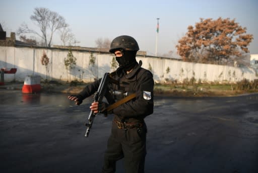 An Afghan policeman stands guard near the entrance gate of the Ministry of Public Works in Kabul on December 25, 2018, a day after a deadly militant attack