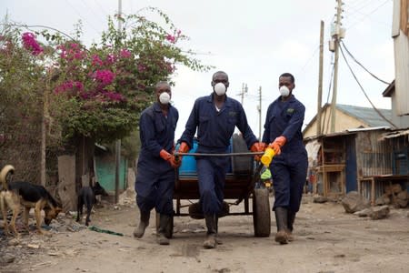 A team of people takes away canisters of human waste from a Sanergy Fresh Life toilet in Mukura Kwa Ruben