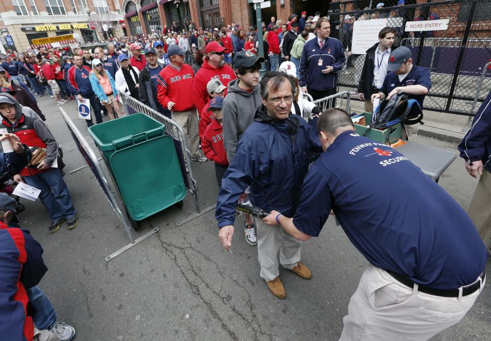 FILE - In this April 20, 2013 file photo, fans pass through security before entering Fenway Park for a baseball game between the Boston Red Sox and the Kansas City Royals in Boston. The Seattle Mariners announced Tuesday, Jan. 21, 2014, that fans entering Safeco Field will have to walk through metal detectors starting with this year's opener. Major League Baseball has told its 30 teams they must implement security screening for fans by 2015. (AP Photo/Michael Dwyer, File)