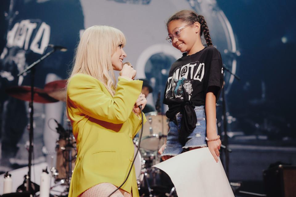 Hayley Williams of Paramore welcomes a young fan, Audrey, on the stage at Fiserv Forum in Milwaukee to sing "Misery Business" on Tuesday, Aug. 1, 2023.