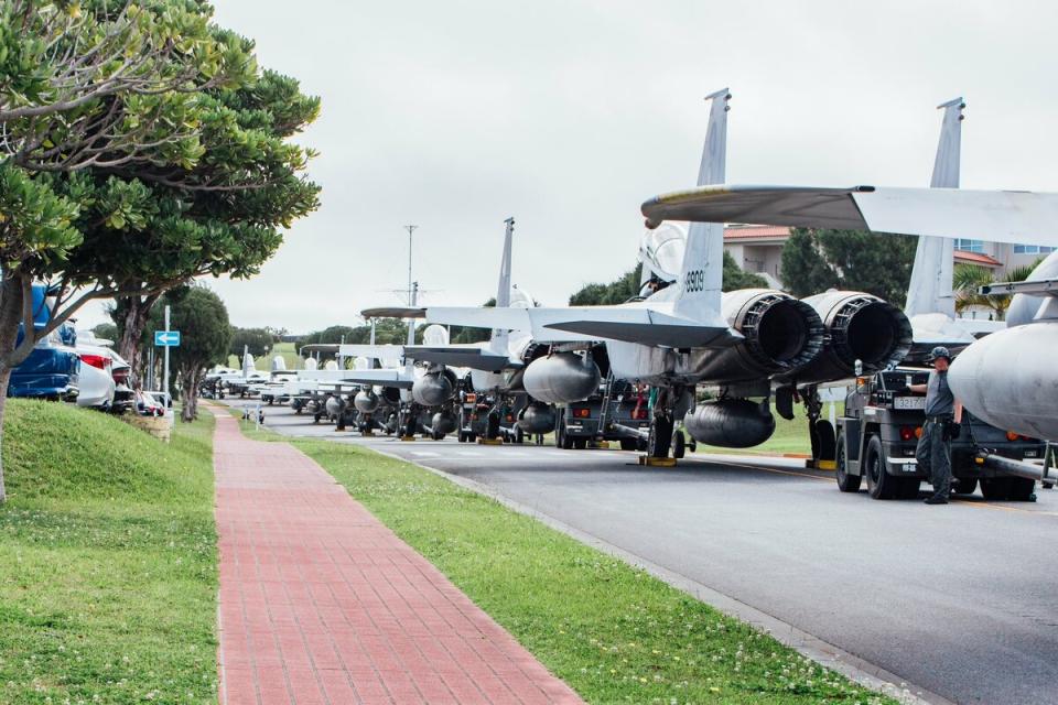 日本航空自衛隊沖繩那霸基地的 F-15J 戰鬥機，為了防止受到海嘯侵襲被轉移至路邊停放，成為一片奇景。   圖：翻攝自 @Naha_AirBase X 帳號