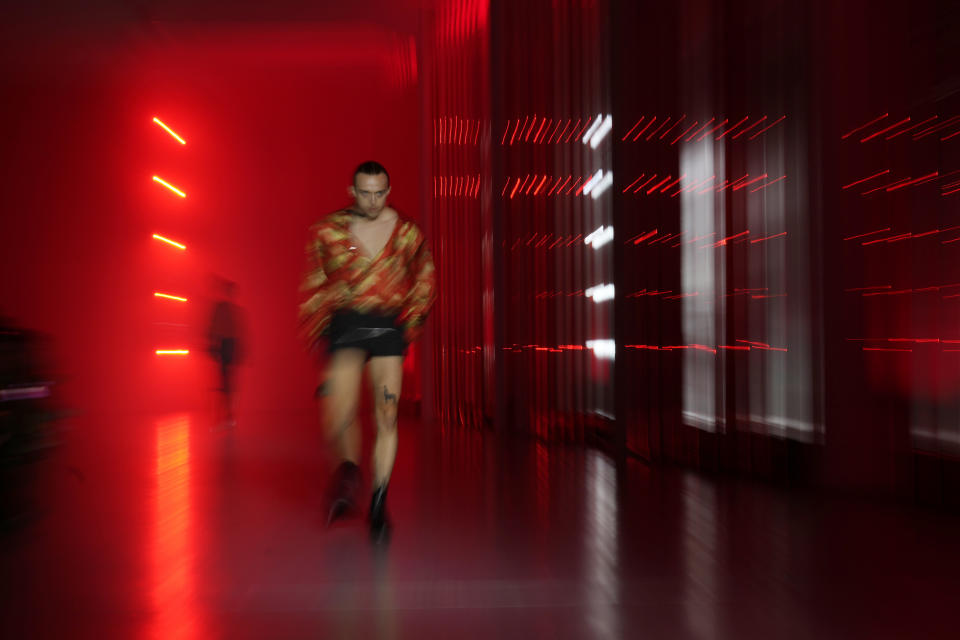 In this image taken with a slow shutter speed, a model wears a creation as part of the Jordanluca men's and women's Spring Summer 2024 collection, unveiled during the Fashion Week in Milan, Italy, Saturday, June 17, 2023. (AP Photo/Antonio Calanni)