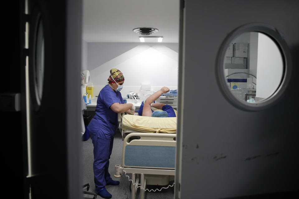 Caroline Erganian is prepared by medical staff for her surgery at Bichat Hospital, AP-HP, in Paris, Wednesday, Dec. 2, 2020. Erganian, 58, hopes to shed more than a third of her weight as a result of having a large part of her stomach cut out and be free of knee and back pain — and of her cane. She prayed in the final weeks that her phone wouldn't ring with news of another delay. (AP Photo/Francois Mori)