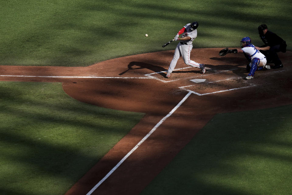 Boston Red Sox's Rafael Devers, left, hits a two-run home run in front of Toronto Blue Jays catcher Alejandro Kirk, second from right, off a pitch from Blue Jays starter Chris Bassitt during the sixth inning of a baseball game in Toronto, Saturday, Sept. 16, 2023. (Chris Young/The Canadian Press via AP)