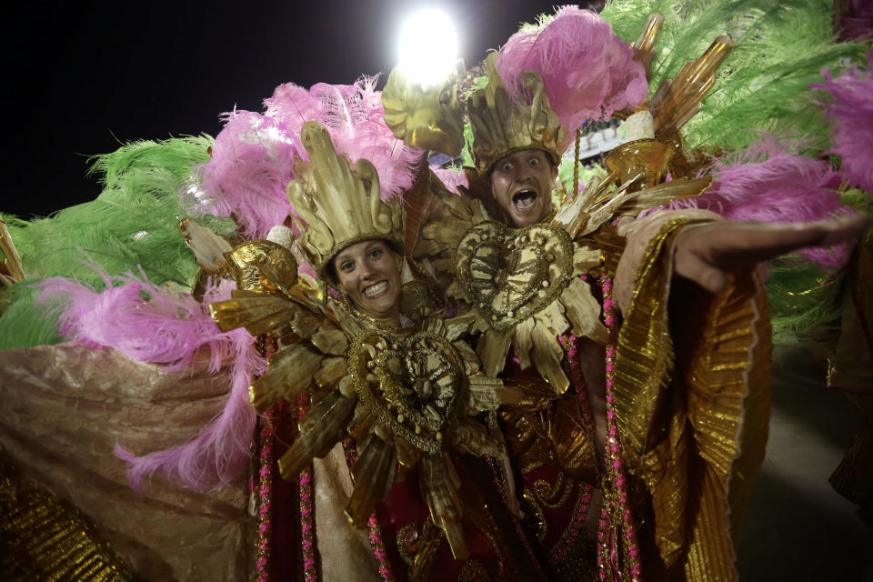 U.S. citizen Paul Leaury, right, and an unidentified fellow foreign member of the Mangueira samba school, dance during a carnival parade at the Sambadrome in Rio de Janeiro, Brazil, Tuesday, Feb. 12, 2013. While non-Brazilians have long shelled out hundreds of dollars for the right to dress up in over-the-top costumes and boogie in Rio's samba school parades, which wrapped up Monday in an all-night extravaganza, few in the so-called "alas dos gringos," or “foreigners' wings,” know how to dance the samba well, bopping along goofily in the parades and waving at the crowds of spectators. (AP Photo/Silvia Izquierdo)