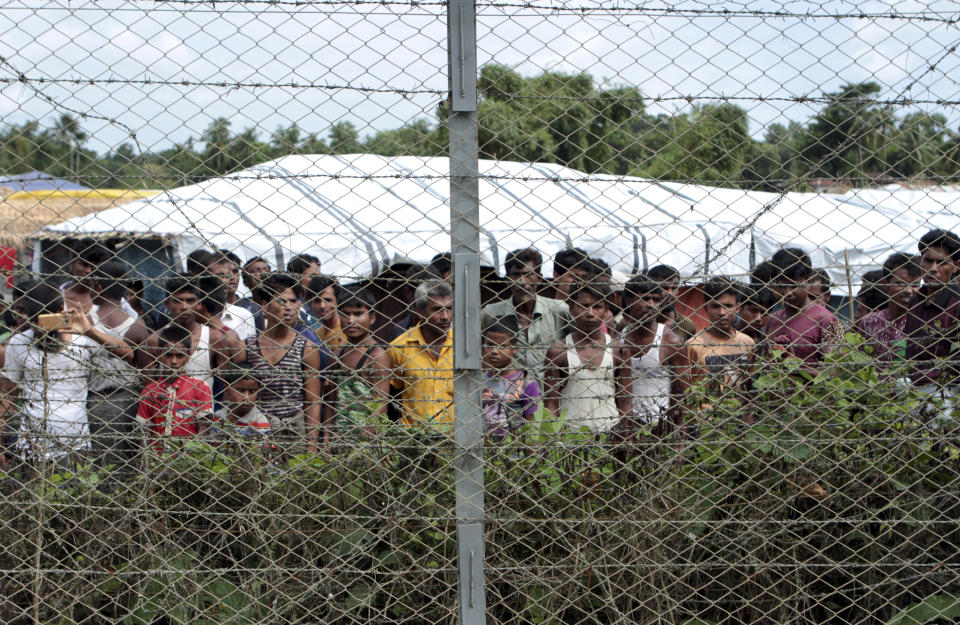 FILE - Rohingya refugees gather near a fence during a government organized media tour, to a no-man's land between Myanmar and Bangladesh, near Taungpyolatyar village, Maung Daw, northern Rakhine State, Myanmar, June 29, 2018. An international case accusing Myanmar of genocide against the Rohingya ethnic minority returns to the United Nations' highest court Monday, Feb. 21, 2022, amid questions over whether the country's military rulers should even be allowed to represent the Southeast Asian nation. (AP Photo/Min Kyi Thein, File)