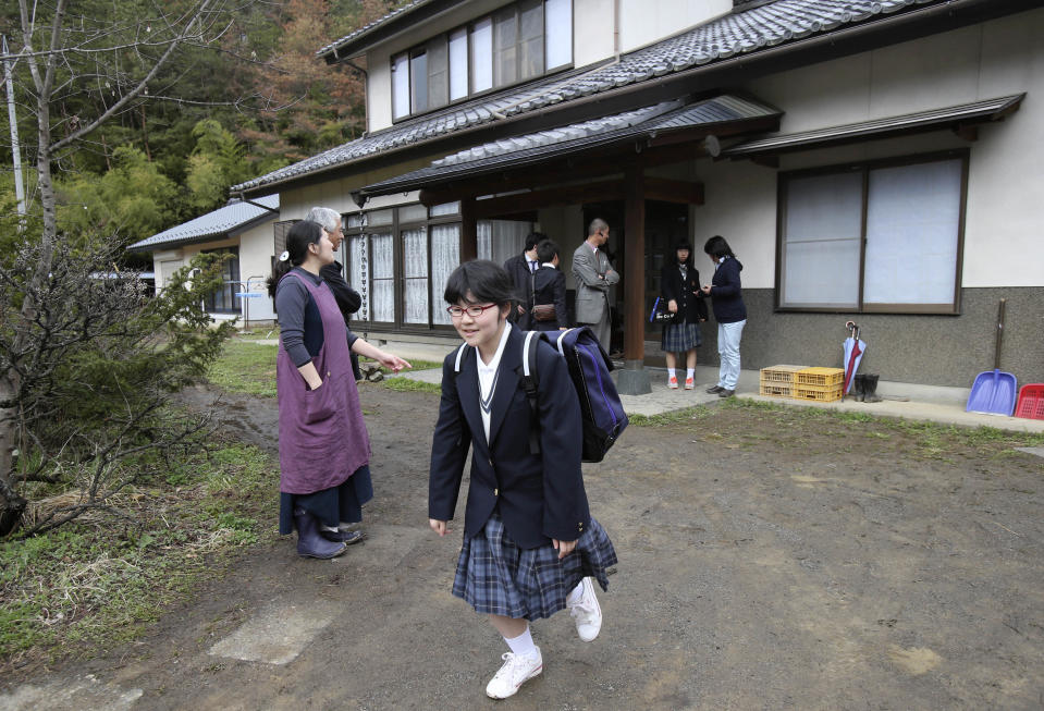 In this Saturday, April 5, 2014 photo, Kokoro Kamiyama, 13, who started her new life after moving from Fukushima, leaves her dormitory to attend an opening ceremony of her Aida junior high school in Matsumoto, central Japan. Kamiyama is the first child to sign on to the Matsumoto project which Chernobyl-doctor-turned-mayor Akira Sugenoya of Matsumoto, offered his Japanese town to get children out of Fukushima. Kamiyama was prone to skipping school when she was in Fukushima, which her mother believes was a sign of stress from worrying about radiation. She is happy she can run around outdoors in the city without wearing a mask. “The air feels so clean here,” Kamiyama said. (AP Photo/Koji Sasahara)