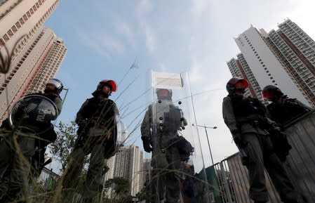 Police officers block the road as anti-government protesters gather in Tin Shui Wai in Hong Kong