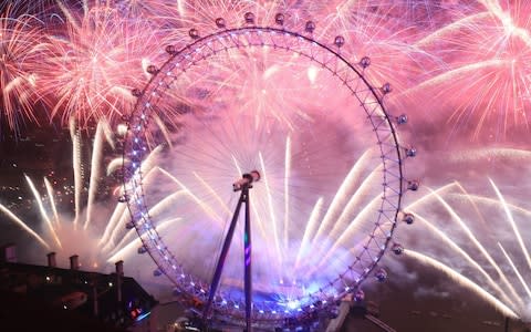 Fireworks light up the sky over the London Eye in central London during the New Year celebrations - Credit: PA