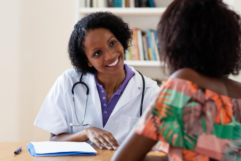 Laughing african american female doctor with patient at hospital