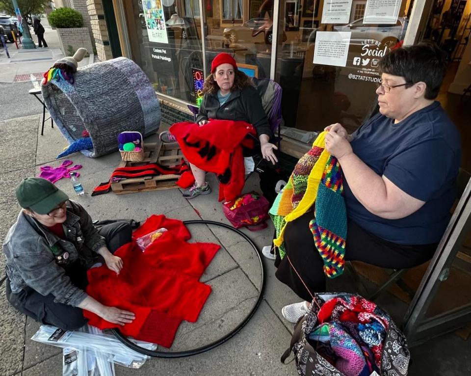 Volunteers work on yarn art on Sixth Street NW in downtown Canton. Yarn art will be unveiled Friday on Sixth and Court Avenue NW; the installation will be on display until September.