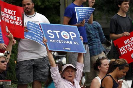 Protesters rally about the Keystone XL oil pipeline along U.S. President Barack Obama's motorcade as he arrives at the Jefferson Hotel in Washington July 11, 2013. REUTERS/Yuri Gripas