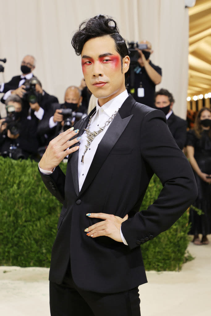 Eugene Lee Yang poses with his hand on his hip on the Met Gala red carpet