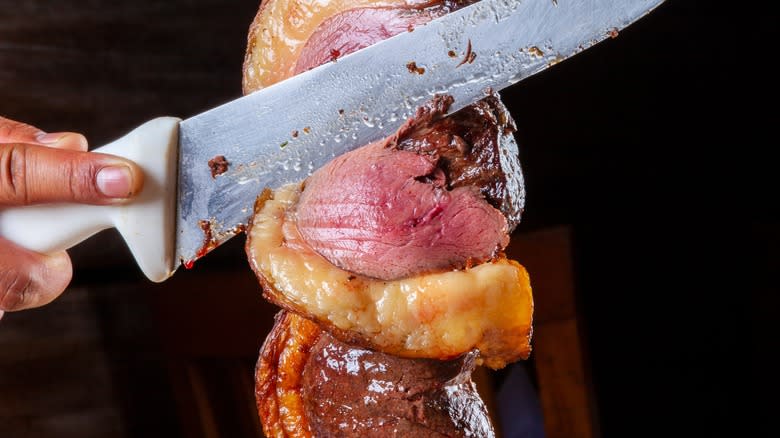 carving picanha beef on skewer