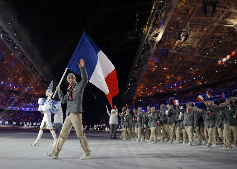 Jason Lamy-Chappuis of France carries the national flag as he leads his team into the stadium during the opening ceremony of the 2014 Winter Olympics in Sochi, Russia, Friday, Feb. 7, 2014. (AP Photo/Patrick Semansky)