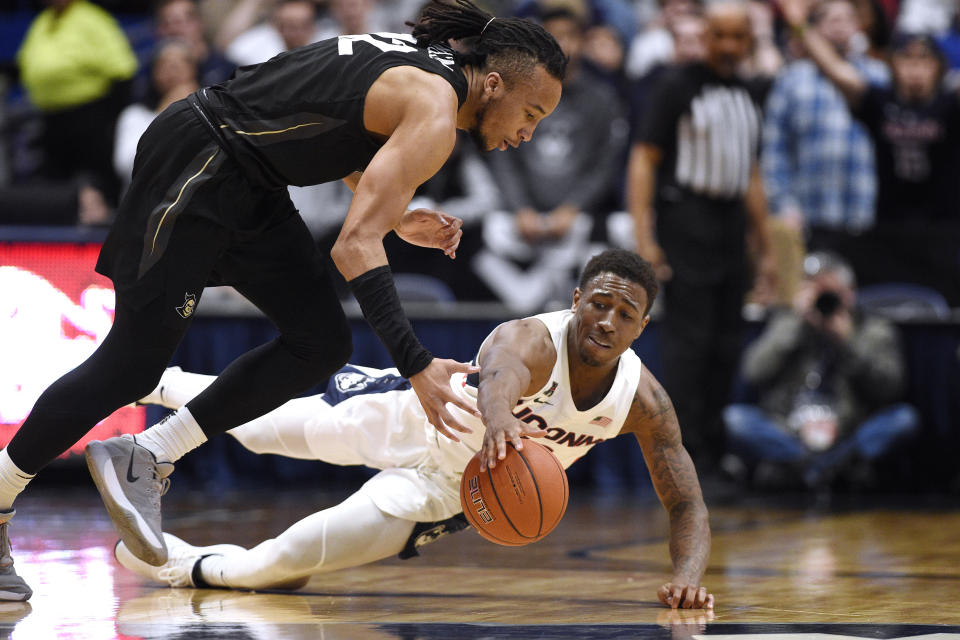 Connecticut's Brendan Adams dives and picks off the ball from Central Florida's Dazon Ingram, left, in the second half of an NCAA college basketball game, Wednesday, Feb. 26, 2020, in Hartford, Conn. (AP Photo/Jessica Hill)