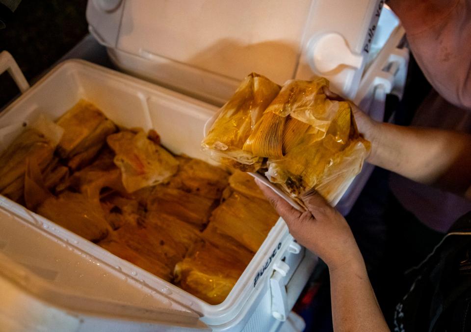 Ana Jimenez of Tamales El Sinai of Perris, Calif., grabs a handful of pork tamales to complete an order during the 30th annual Indio International Tamale Festival at Miles Avenue Park in Indio, Calif., Thursday, Dec. 1, 2022. 