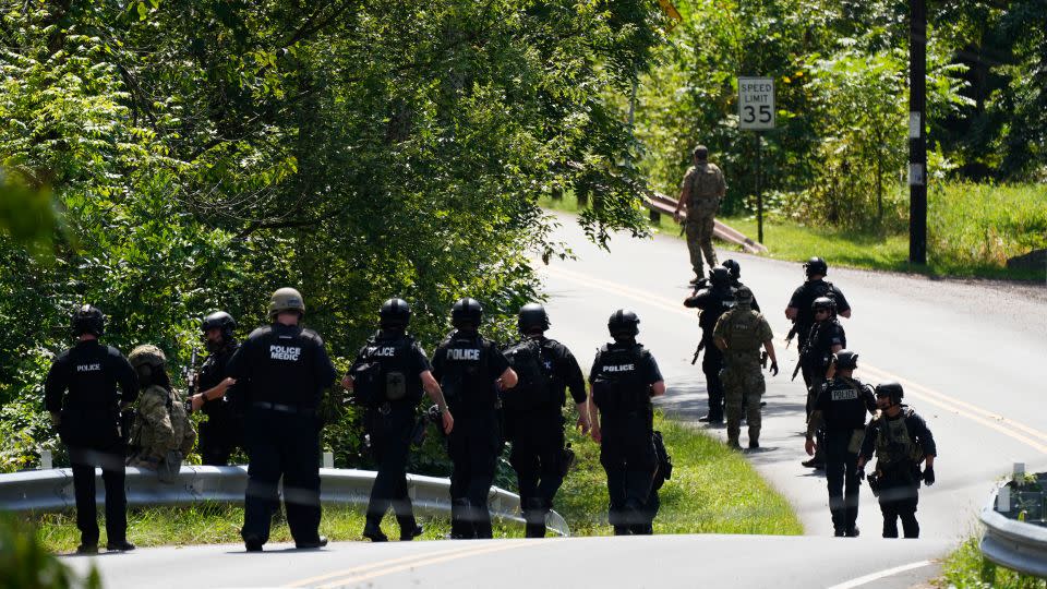 Law enforcement officers gather as the search for escaped convict Danelo Cavalcante continues Tuesday. - Matt Rourke/AP