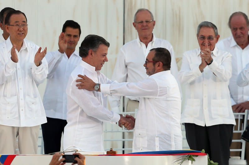 「哥倫比亞革命武裝力量人民軍」（FARC）的最高指揮官隆多尼奧（Rodrigo Londoño，右）要與哥倫比亞總統桑托斯（Juan Manuel Santos）在正式簽署停火協議的儀式上握手慶賀。（美聯社）