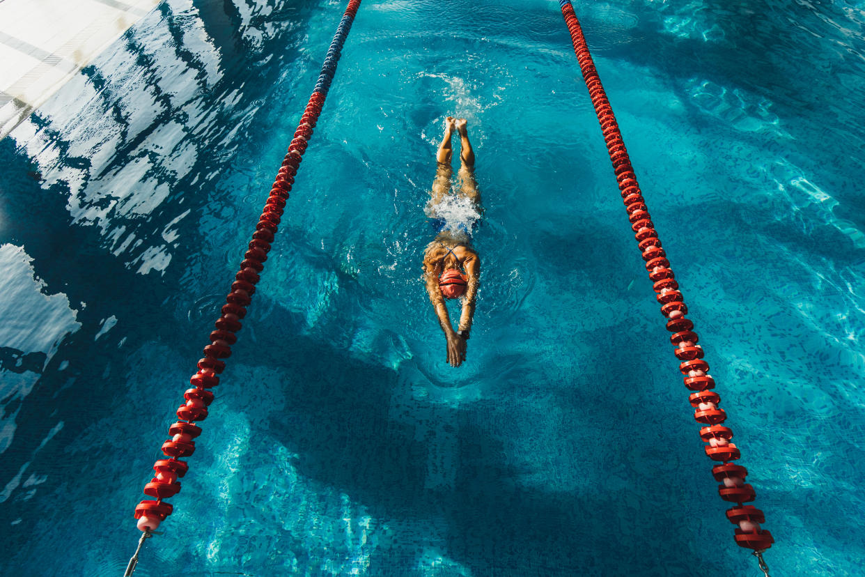 Swimming workout in pool. Clear and blue water surface. Healthy lifestyle, sportive hobby. Professional sportswoman. Triathlon training.