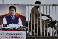 A motorcyclist moves past a poster with images of Imran Khan as it is displayed in the celebration of his government on a bridge in Islamabad, Pakistan, Saturday, Aug. 18, 2018. Pakistan's cricket star-turned-politician Khan was sworn in as prime minister on Saturday despite protests by opposition parties, which accuse the security services of intervening on his behalf in last month's elections. The poster reads 'Welcome to this new government with new hopes and aspiration'. (AP Photo/Anjum Naveed)