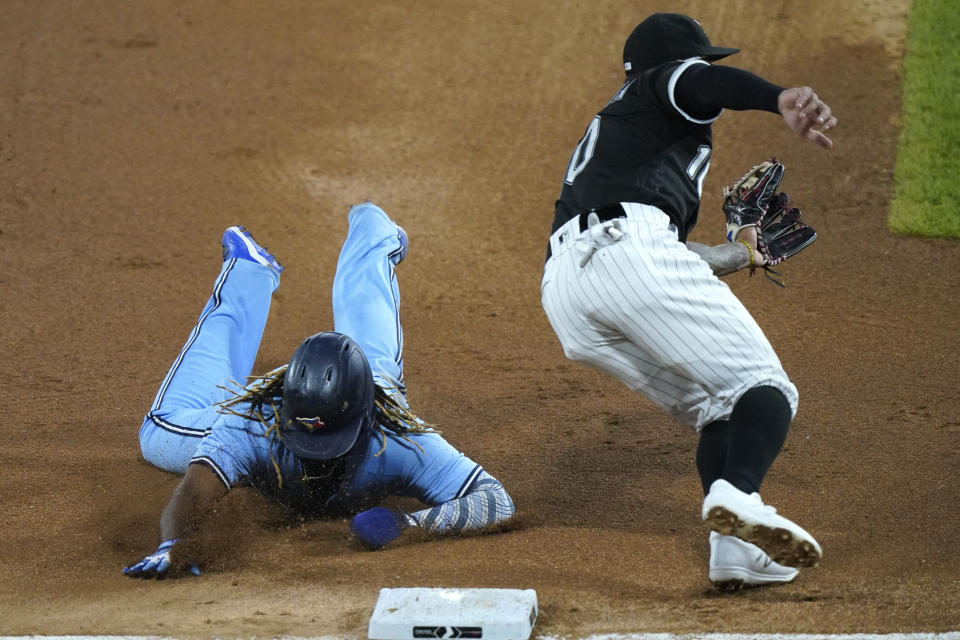 Toronto Blue Jays' Vladimir Guerrero Jr., left, arrives safely at third against Chicago White Sox third baseman Yoan Moncada during the sixth inning of a baseball game in Chicago, Thursday, June 10, 2021. Wild pitch by Chicago White Sox starting pitcher Dallas Keuchel. (AP Photo/Nam Y. Huh)