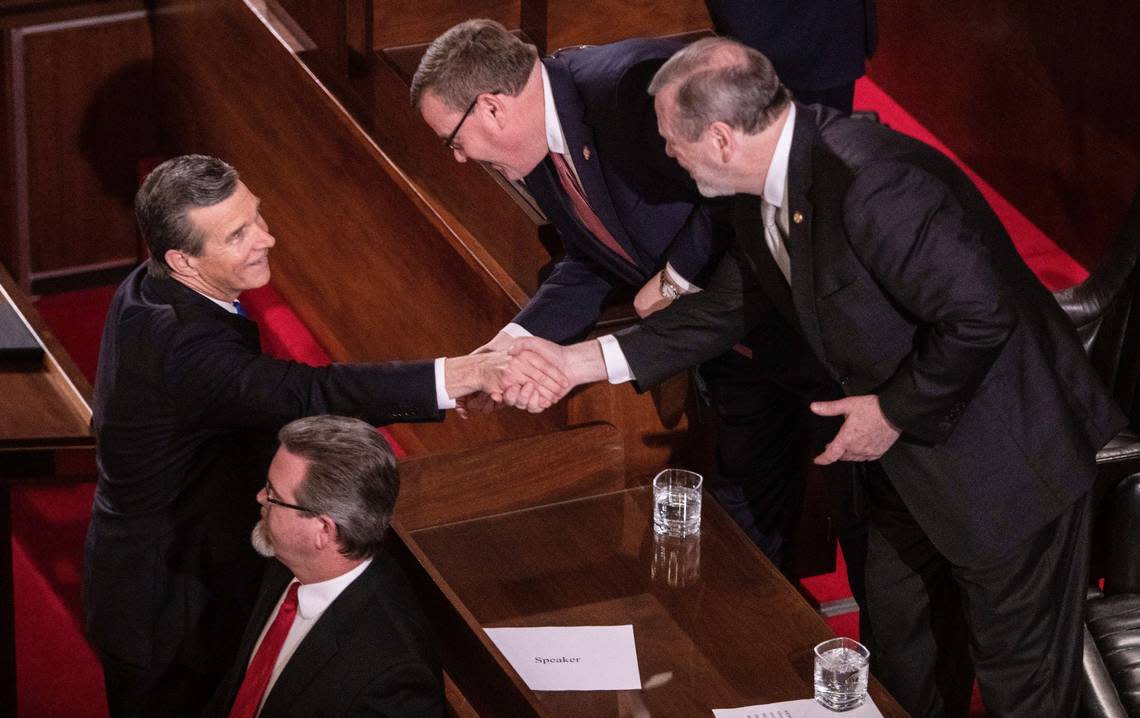Gov. Roy Cooper, left, shakes hands with House Speaker Tim Moore, center and Senate Leader Phil Berger prior to Cooper’s biennial State of the State address to a joint session of the General Assembly at the Legislative Building Monday evening, Feb. 26, 2019.