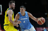 Argentina's Luis Scola (4) drives around Australia's Nic Kay during a men's basketball quarterfinal round game at the 2020 Summer Olympics, Tuesday, Aug. 3, 2021, in Saitama, Japan. (AP Photo/Eric Gay)