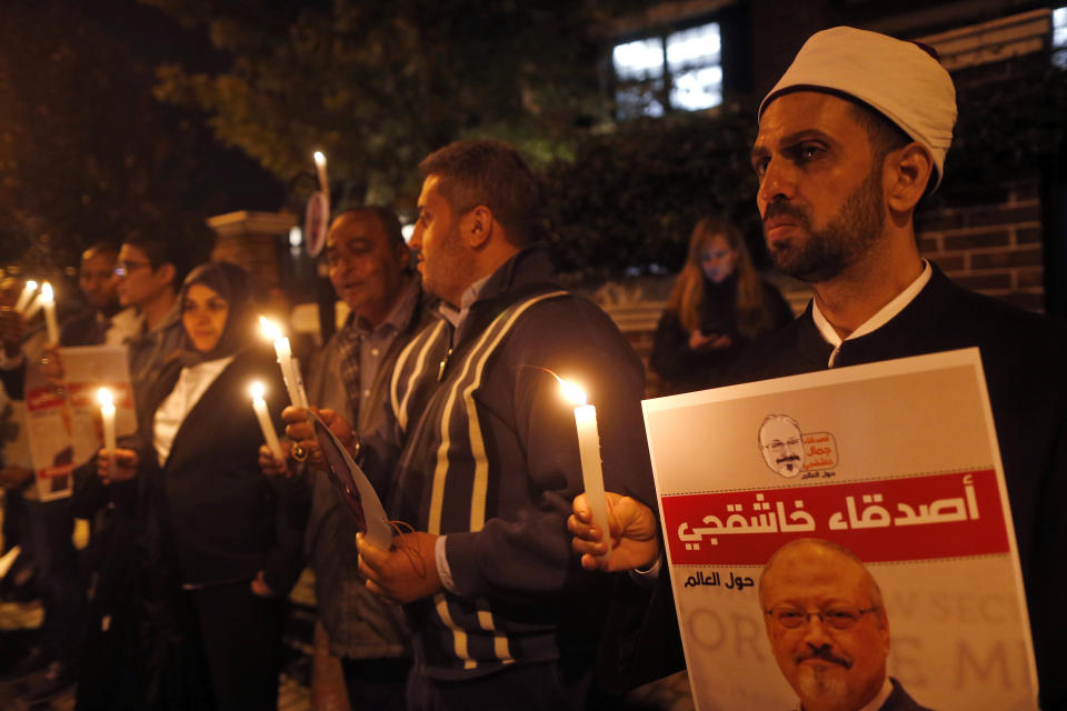 Activists, protesting the killing of Saudi journalist Jamal Khashoggi, hold a candlelight vigil outside Saudi Arabia's consulate in Istanbul, Thursday, Oct. 25, 2018. The poster reads in Arabic:' Khashoggi's Friends Around the World'. A group of Arab and international public, political and media figures are establishing a global association called "Khashoggi's Friends Around the World"; "to achieve justice for the freedom martyr". (AP Photo/Lefteris Pitarakis)