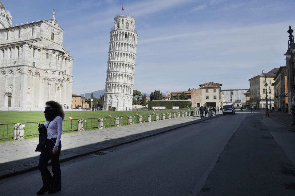 A woman walks near the Tower of Pisa in the semi-deserted Piazza dei Miracoli on March 10, 2020. The Italian government has imposed unprecedented restrictions on its 60 million people as it expanded its emergency coronavirus lockdown nationwide. (Photo by Laura Lezza/Getty Images)