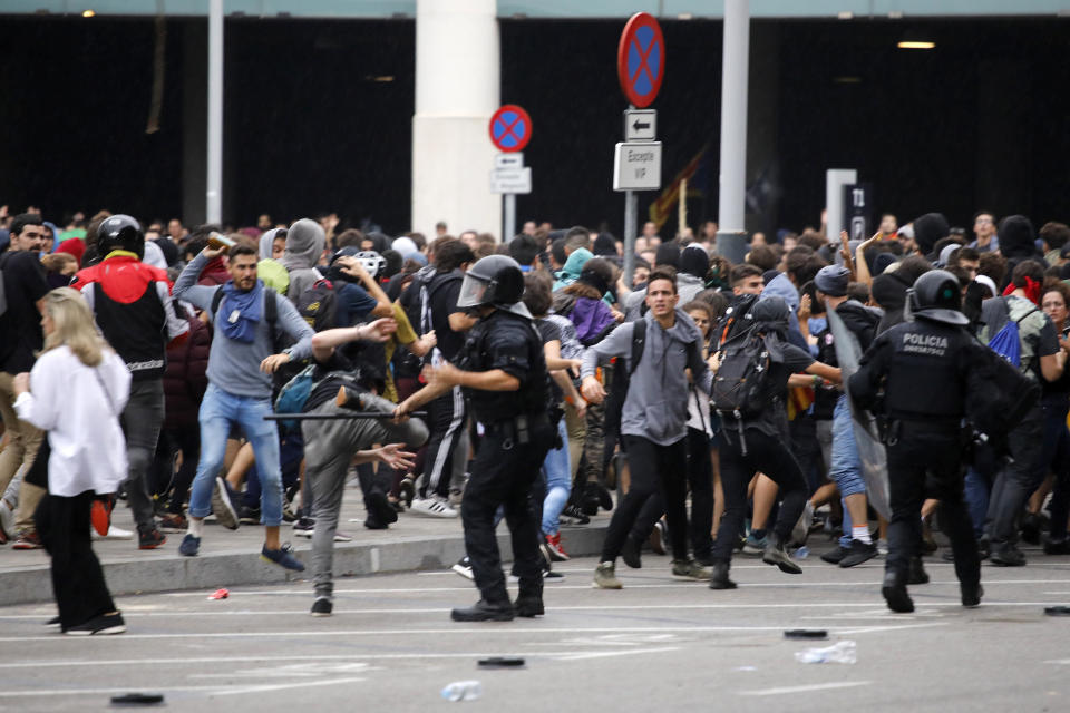 Riot policemen clash with protestors outside El Prat airport in Barcelona, Spain, Monday, Oct. 14, 2019. Riot police have charged at protesters outside Barcelona's airport after the Supreme Court sentenced 12 prominent Catalan separatists to lengthy prison terms for their roles in a 2017 push for the wealthy Spanish region's independence. (AP Photo/Emilio Morenatti)