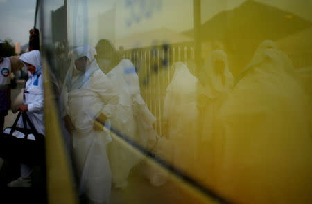 Iranian pilgrims are seen reflected in a bus door upon their arrival for the annual haj pilgrimage, in Arafat outside the holy city of Mecca, Saudi Arabia August 30, 2017. Picture taken August 30, 2017. REUTERS/Suhaib Salem