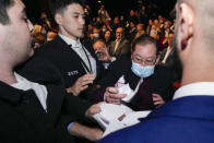 A guest rips a placard held by a protester as he is escorted by security during the address by China's Ambassador to Australia, Xiao Qian on the state of relations between Australia and China at the University of Technology in Sydney, Australia, Friday, June 24, 2022.(AP Photo/Mark Baker)