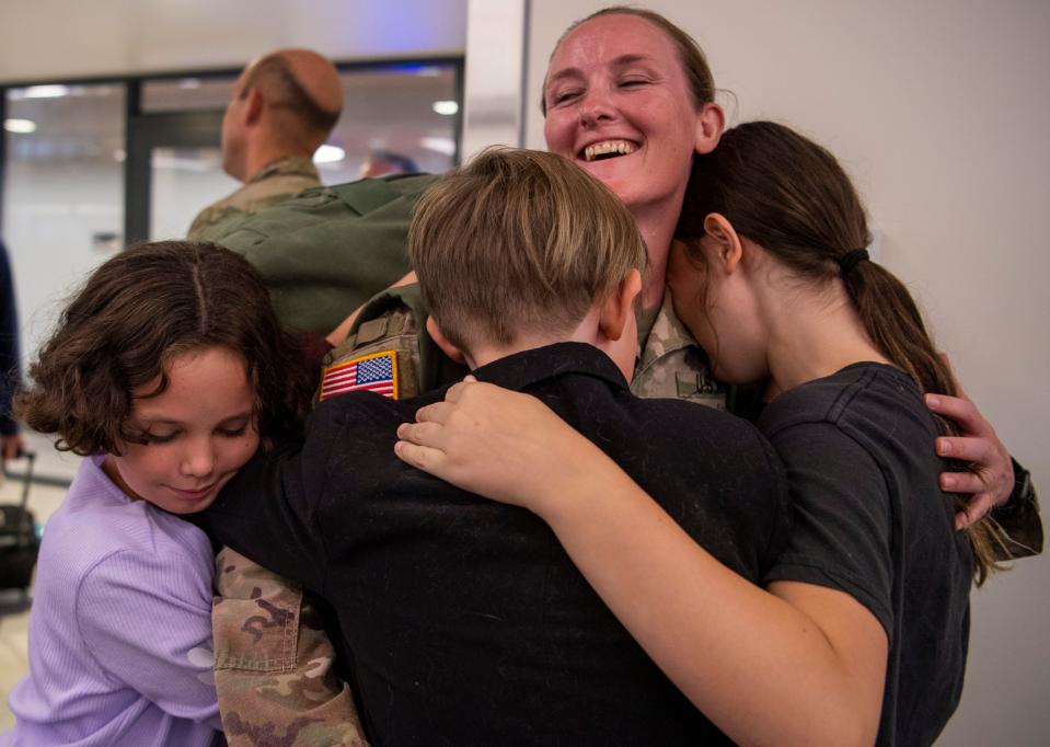 Sgt. Lindsey Keene is hugged by her children on arrival after serving in Iraq for a year with the 1st Detachment of the 1st Battalion, 163rd Field Artillery of the Indiana Army National Guard at the Evansville Regional Airport after a year in Iraq Thursday, Aug. 3, 2023.