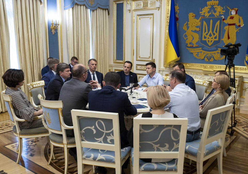 Ukrainian president Volodymyr Zelenskiy, center, speaks during a meeting with lawmakers in Kiev, Ukraine, Tuesday, May 21, 2019. Zelenskiy dropped a bombshell when he said he is dissolving the parliament, dominated by allies of the former Ukrainian president. Zelenskiy sat down with political leaders Tuesday morning to discuss the dissolution. (Ukrainian Presidential Press Office via AP)