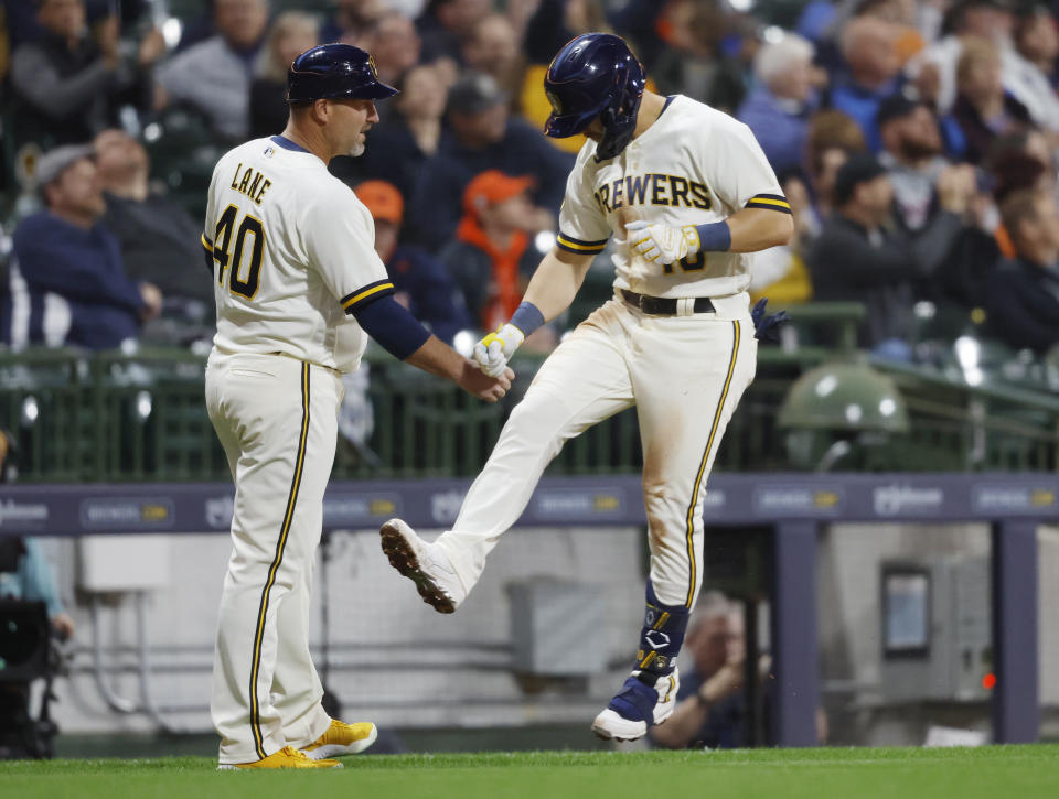 Milwaukee Brewers' Mike Brosseau (10) reacts with third base coach Jason Lane after hitting a home run against the Detroit Tigers during the third inning of a baseball game Monday, April 24, 2023, in Milwaukee. (AP Photo/Jeffrey Phelps)