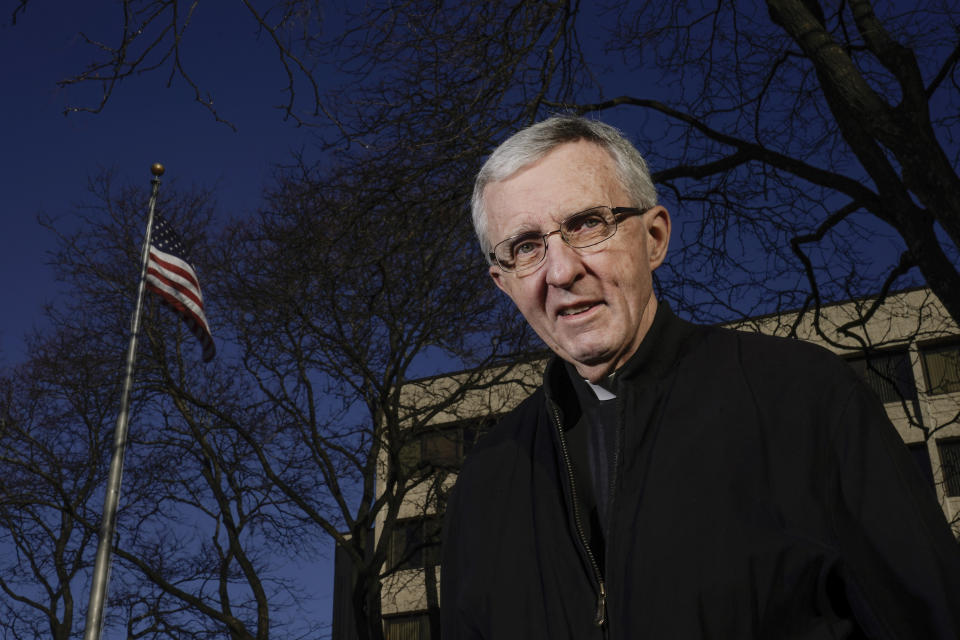 Father Jim Connell poses for a portrait outside his home in Milwaukee on Wednesday, Dec. 2, 2020. Connell, a retired administrator in the Milwaukee Archdiocese who is also a canon lawyer, said AP’s findings convinced him that Catholic entities did not need government aid -- especially when thousands of small businesses were permanently closing amid state-ordered health lockdowns. “Was it want or need?” Connell asked. “Need must be present, not simply the want. Justice and love of neighbor must include the common good.” (AP Photo/Morry Gash)