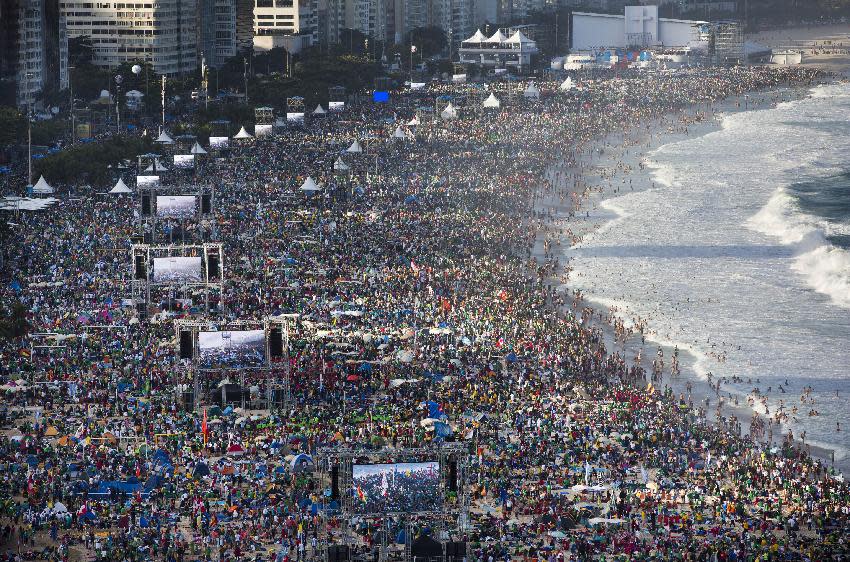 FILE -- In this file photo taken on July 27, 2013, pilgrims and residents gather on Copacabana beach before the arrival of Pope Francis for World Youth Day in Rio de Janeiro, Brazil. Francis' flouting of rules has extended to saints (he's declared three of them without going through the Vatican's miracle-confirmation protocol) and to security: He ditched the armored popemobile for his first foreign trip to Brazil, and promptly got swarmed by adoring crowds in Rio when his motorcade took a wrong turn. (AP Photo/Felipe Dana)