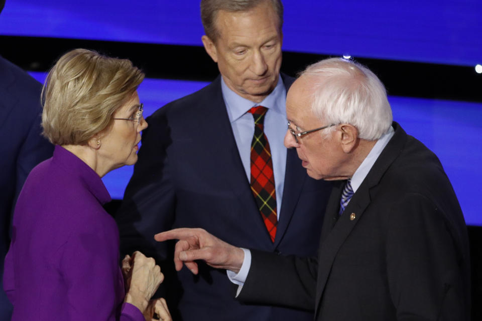 Democratic presidential candidate Sen. Elizabeth Warren, D-Mass., left and Sen. Bernie Sanders, I-Vt., talk Tuesday, Jan. 14, 2020, after a Democratic presidential primary debate hosted by CNN and the Des Moines Register in Des Moines, Iowa., as businessman Tom Steyer looks on. (AP Photo/Patrick Semansky)